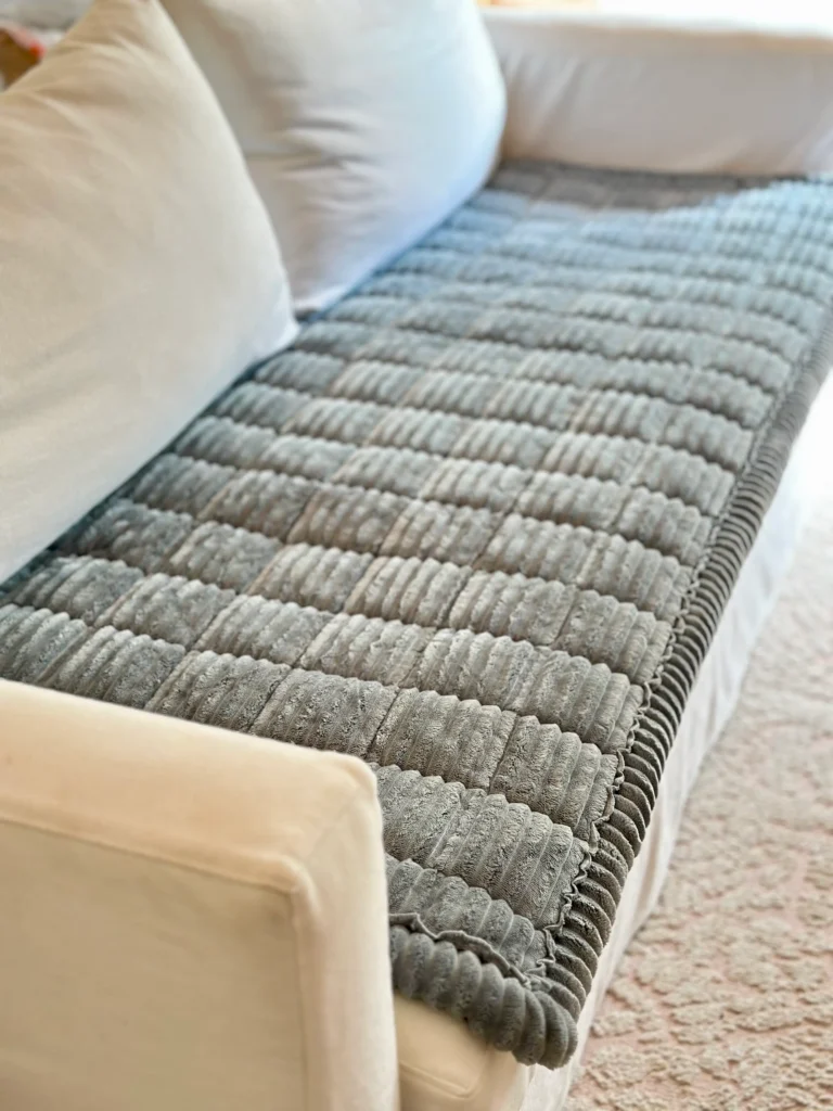 Blue sofa topper on white slipcovered sofa.