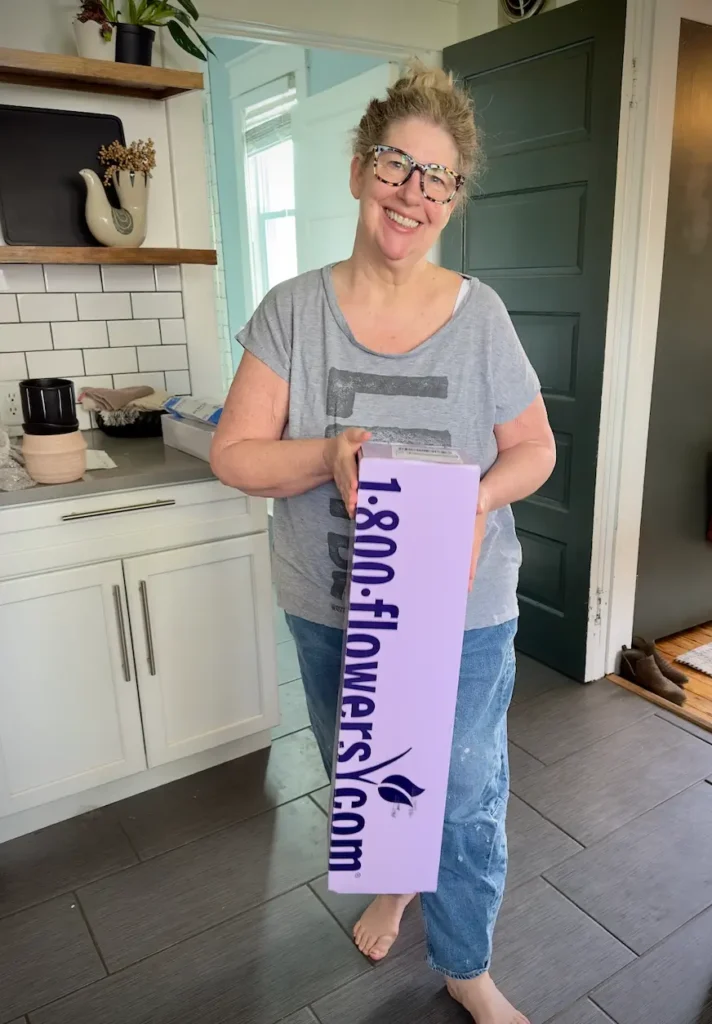 Woman holding delivery box from 1-800-Flowers