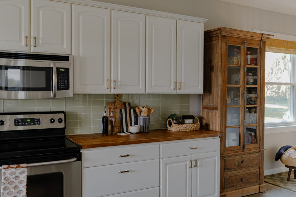 Add warmth to a White Kitchen with Wood Storage Pantry.