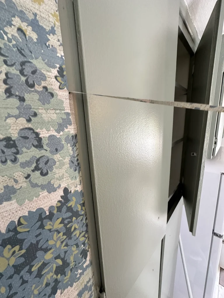 Peel-and-stick wallpaper is being framed in an English Cottage Kitchen.